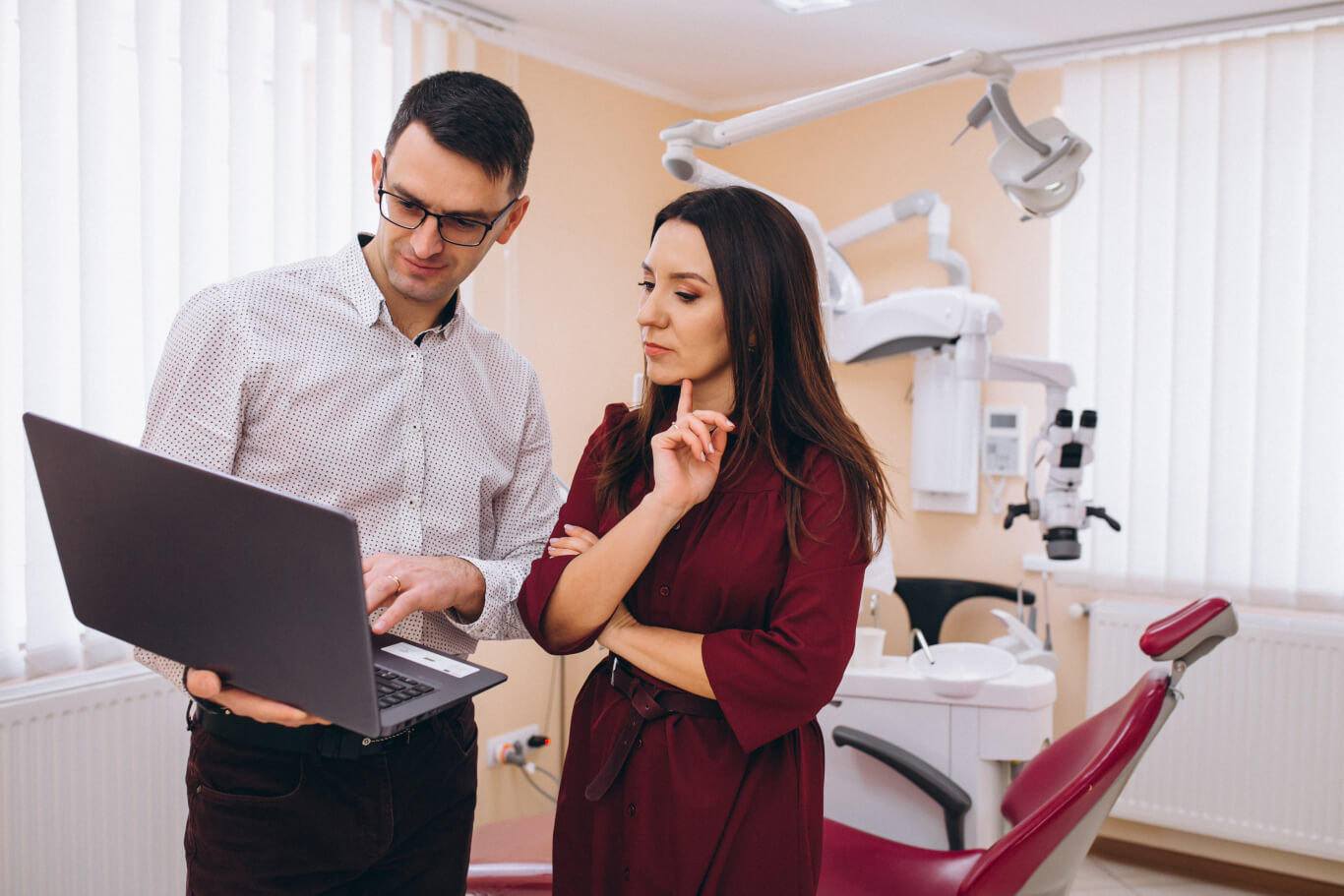 DMA technician reviewing a laptop with a dental team member in an operatory